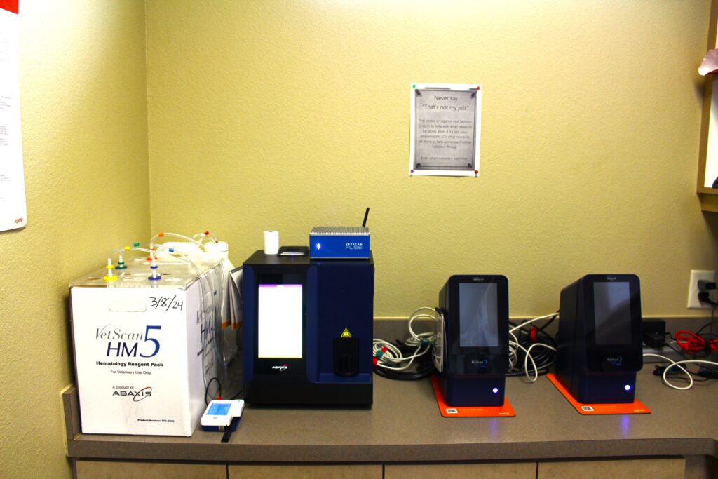 Laboratory counter with various medical devices and a motivational poster.
