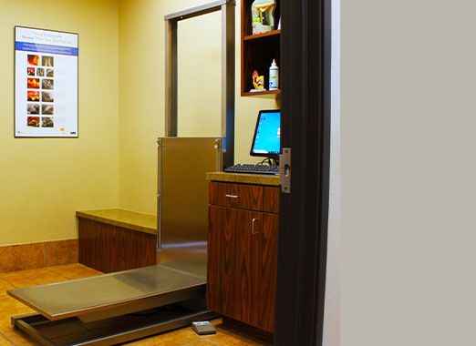 Veterinary clinic reception desk with a computer and a walk-on weighing scale.